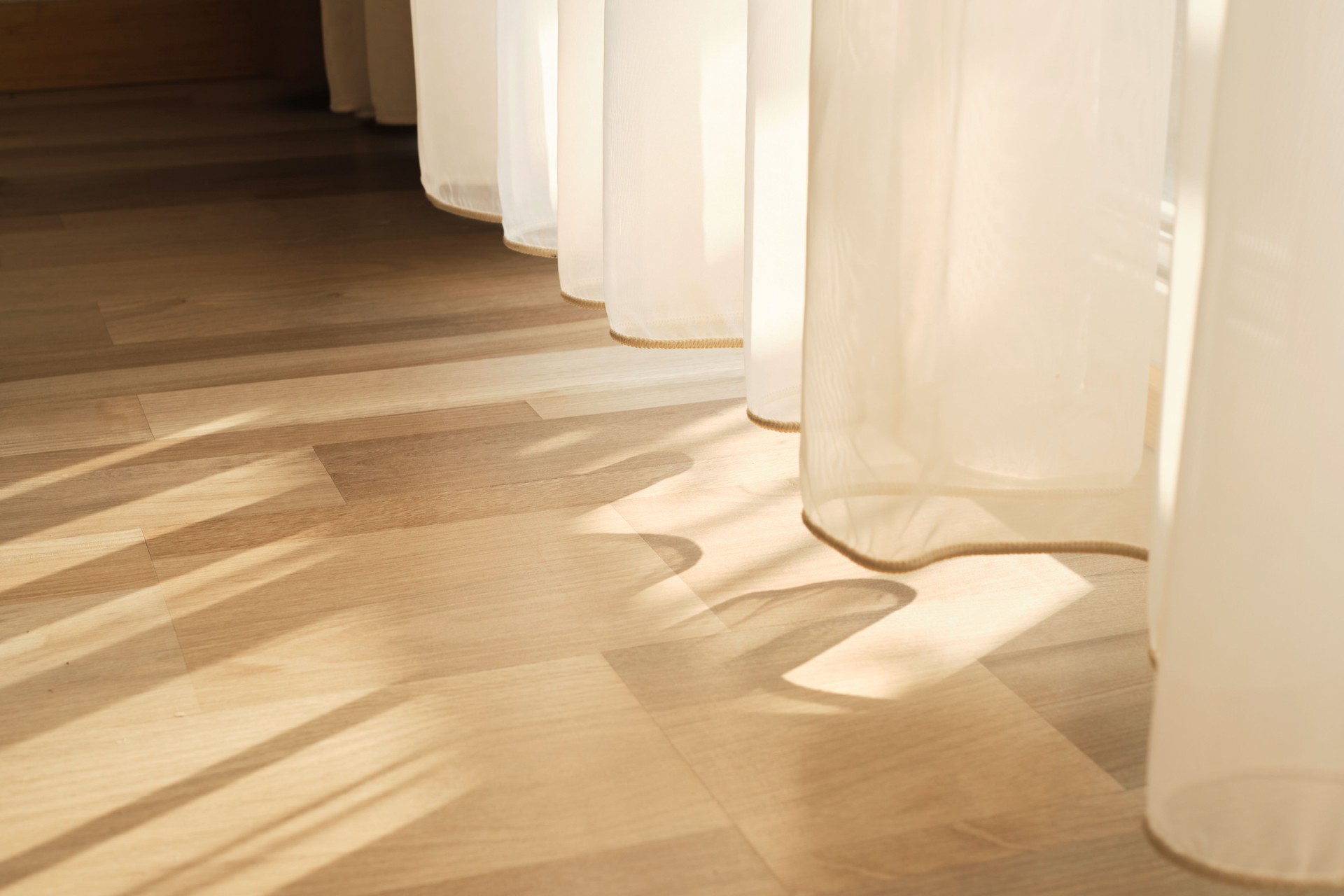 peaceful morning, the wind subtly moves the blinds in a hotel suite, making way for rays of sunlight that shine through and fill the room with natural light.